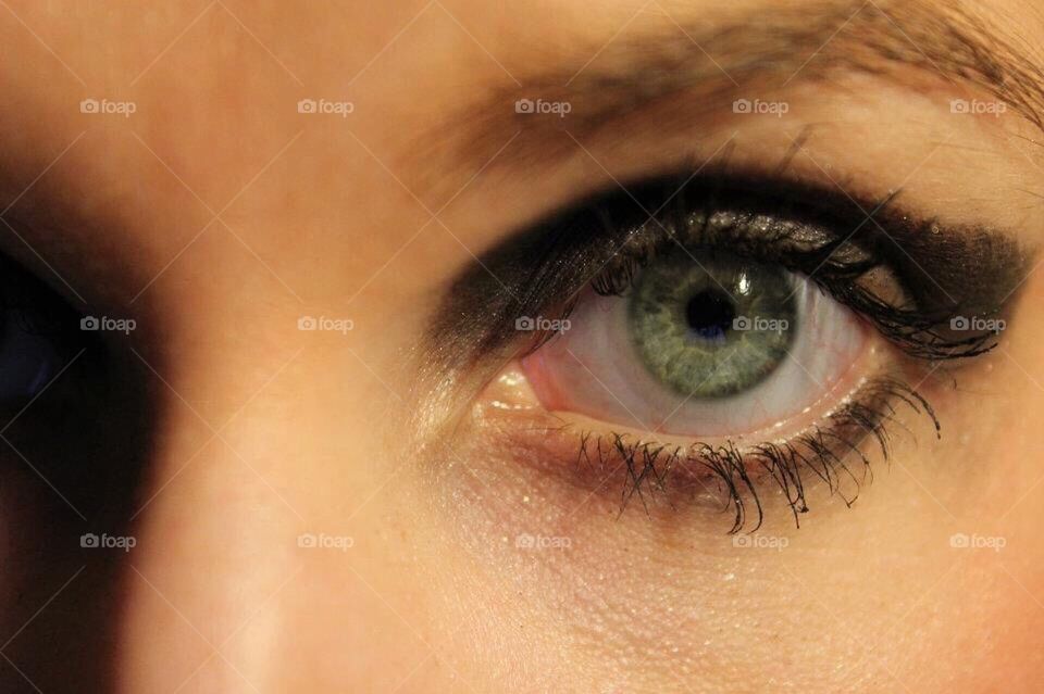 Close up of a green eye with makeup