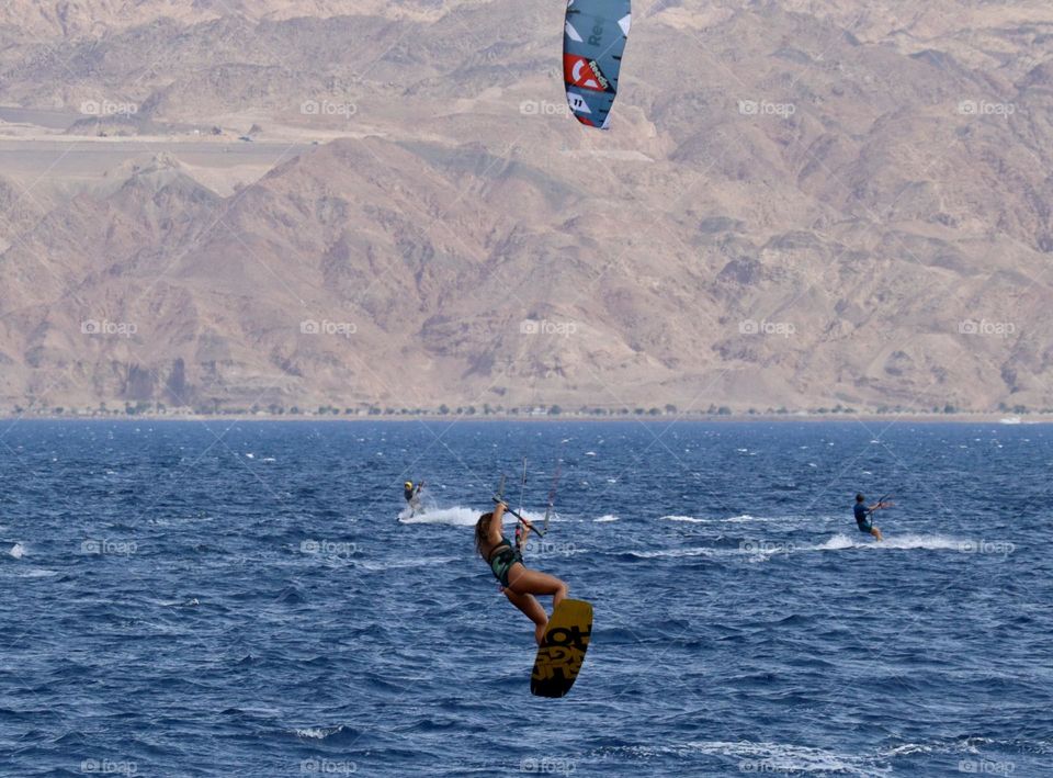 Woman do big jump during kitesurfing 