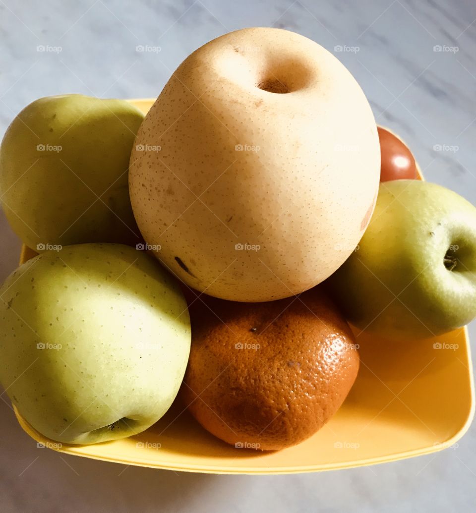 Vitamins C Healthy fruits apples Tomato’s orange on yellow  bowl white  background 