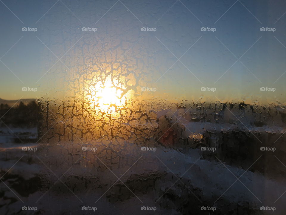 Sunrise through icy window. 