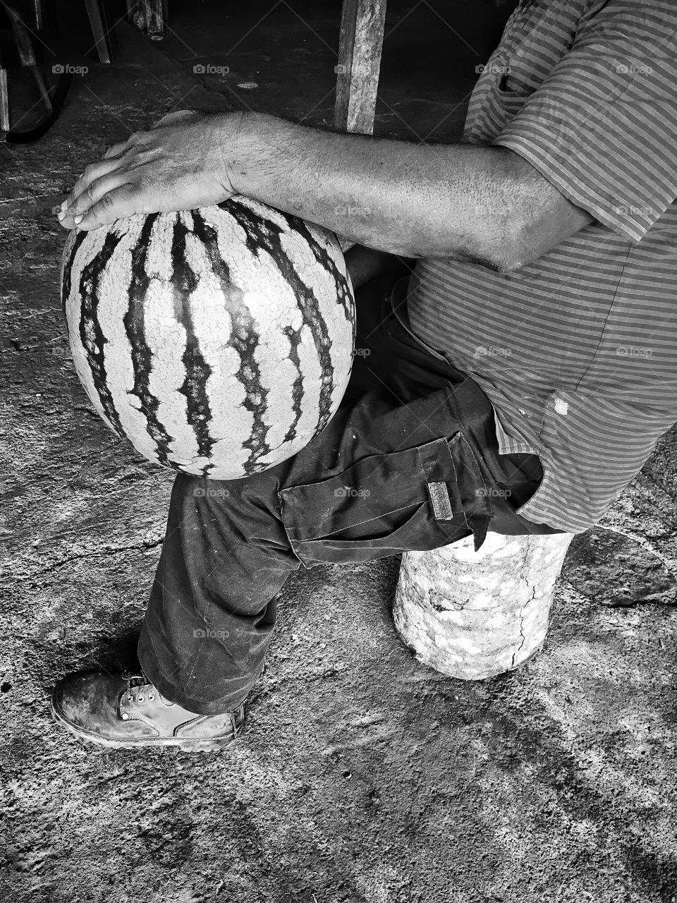 Black and white watermelon on mechanics knee.