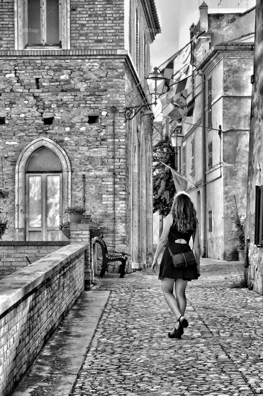 A girl walking in a small town in Marche. Italy