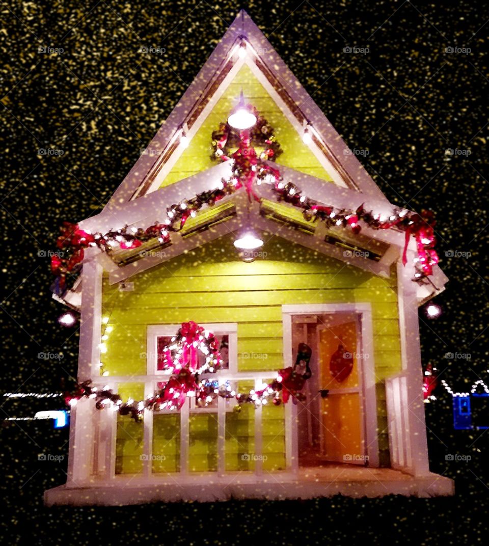 adorable mini Christmas Cottage decorated ornately with Christmas decorations set up for the enjoyment of park goers