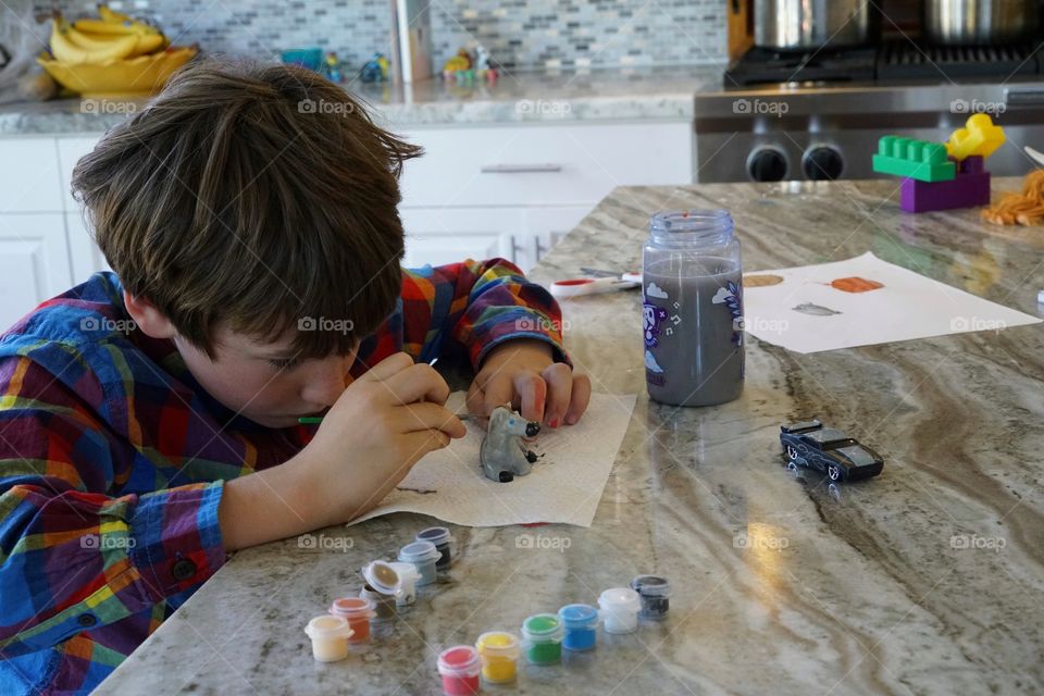 Young Boy Painting A Ceramic Toy