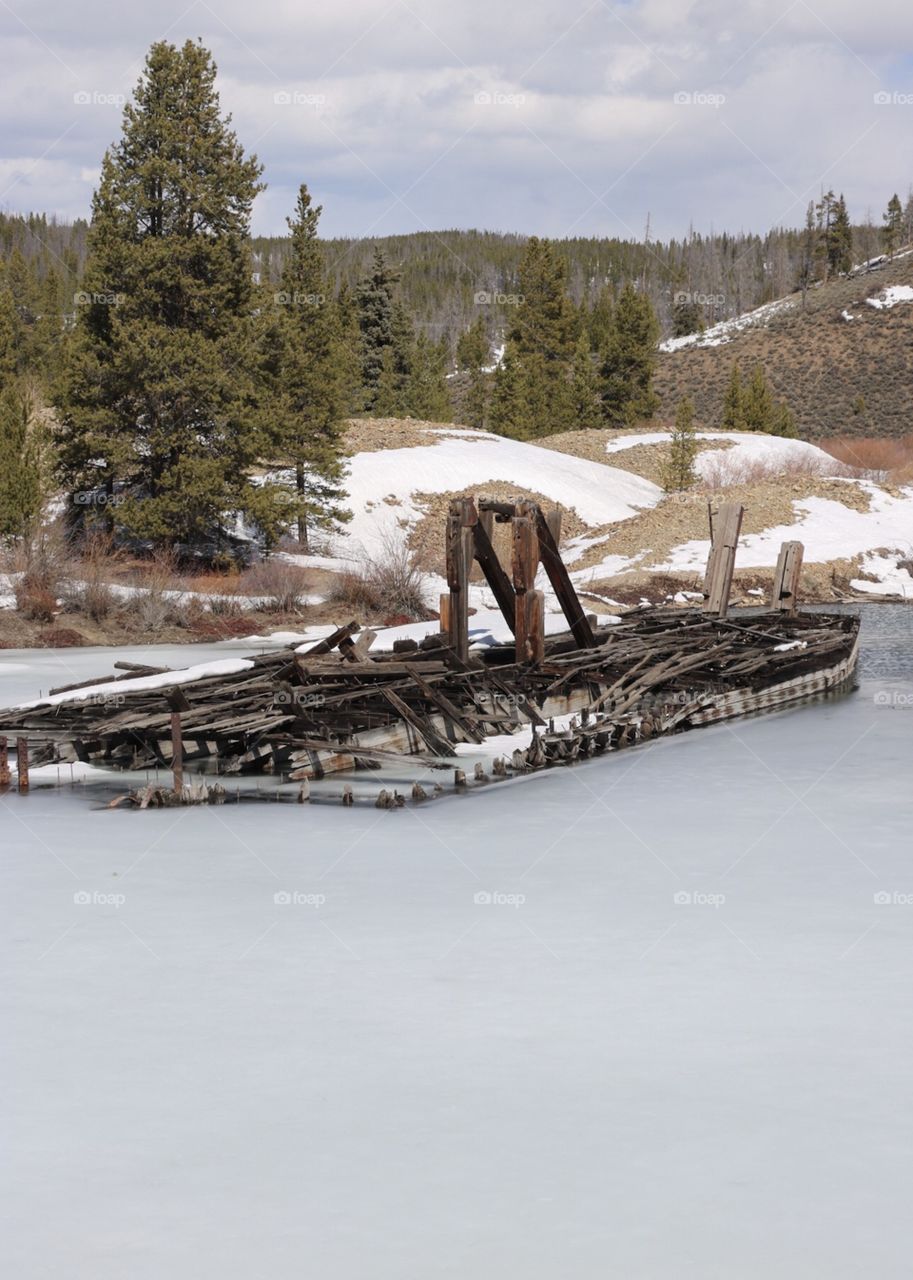 An abandoned gold mining dredge, frozen in a mountain lake in Colorado. 