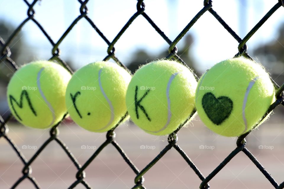 Tennis balls in fence as part of a memorial for a retired high school teacher and coach. Shot on Canon 6D Mark II