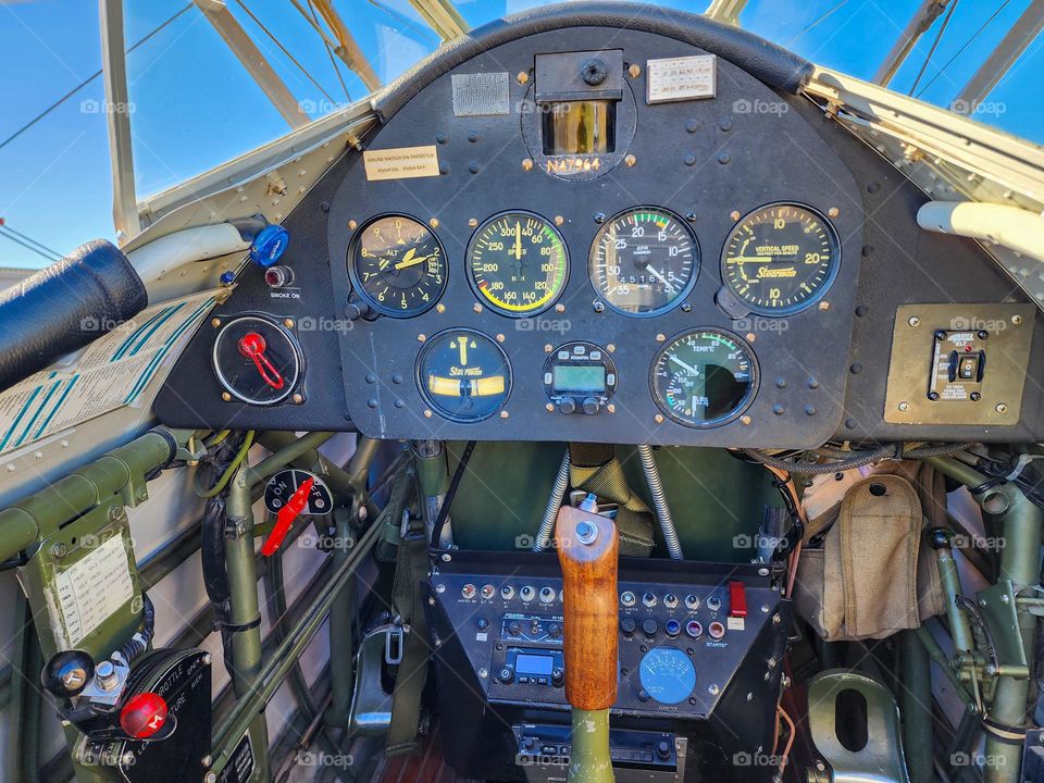 Various circular instruments in the cockpit of a biplane provide critical information to the pilot