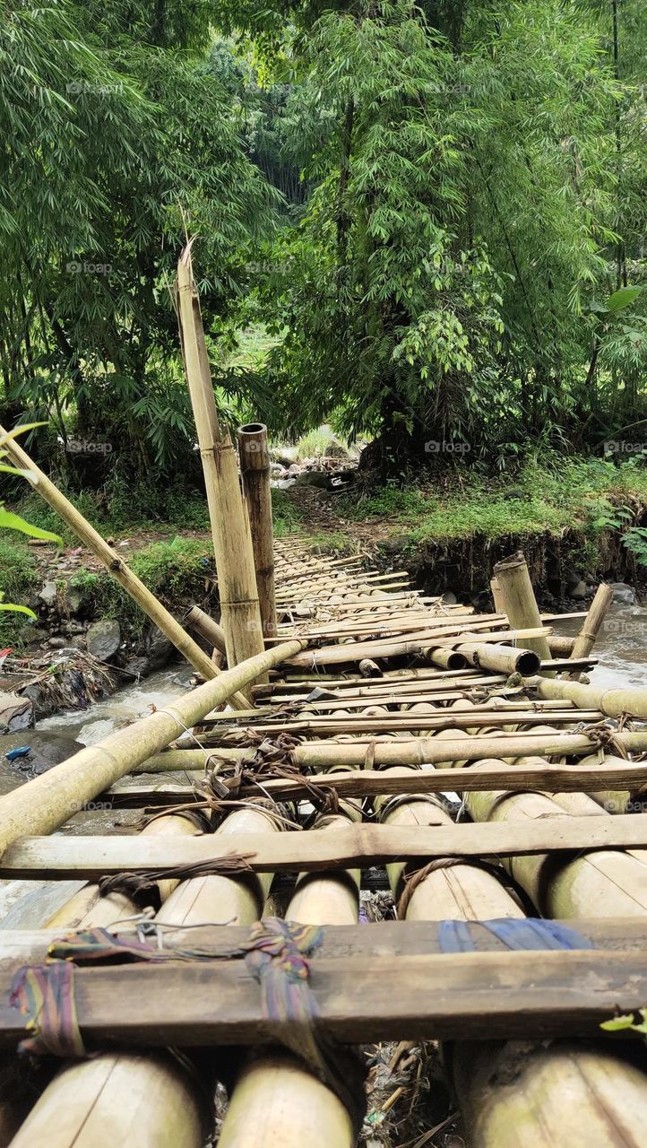 melalui jembatan bambu