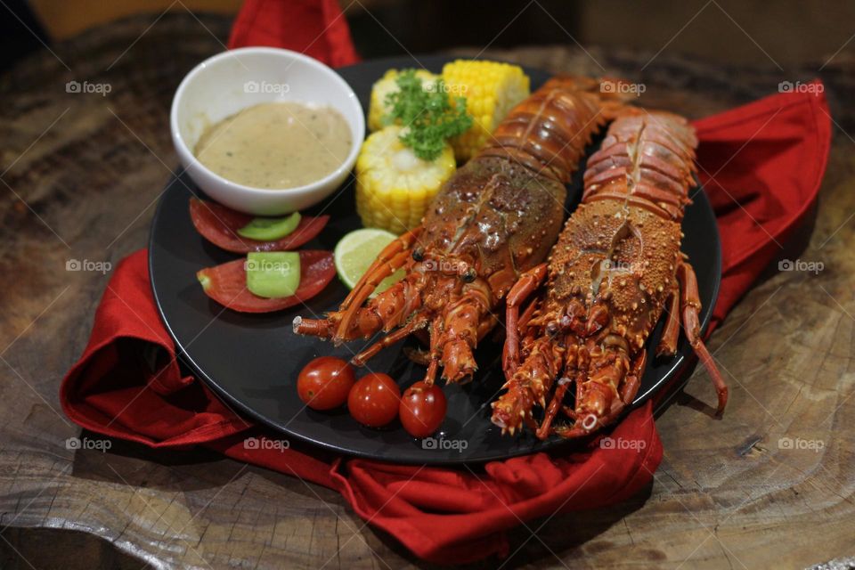 Lobster creamy garlic Lobster served with corn, tomatoes, lemon wedges, cherry and Asian-style creamy garlic sauce.