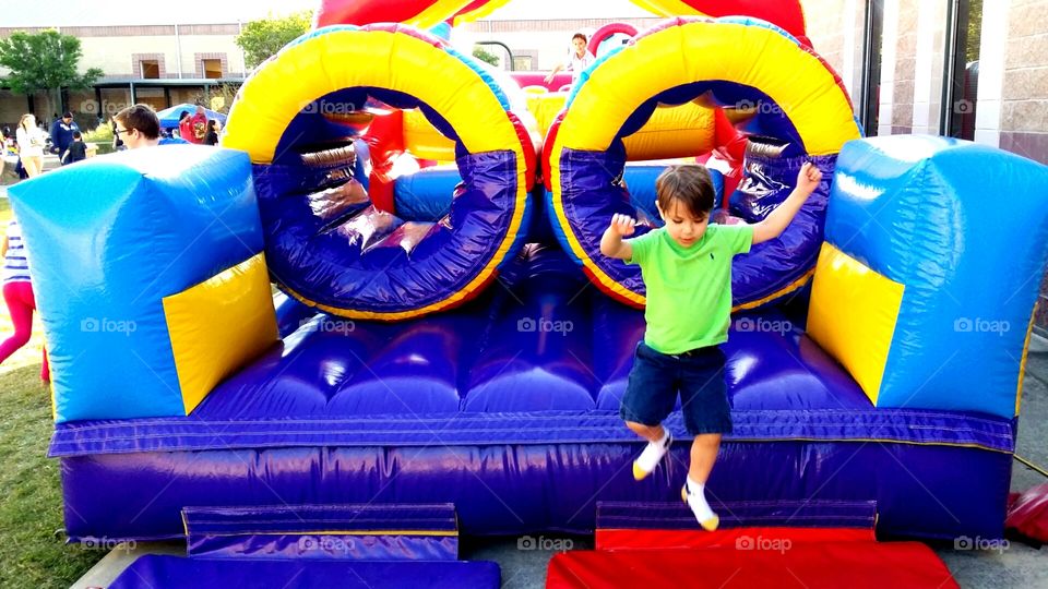 Romping. Child running and jumping through inflatable obstacle course