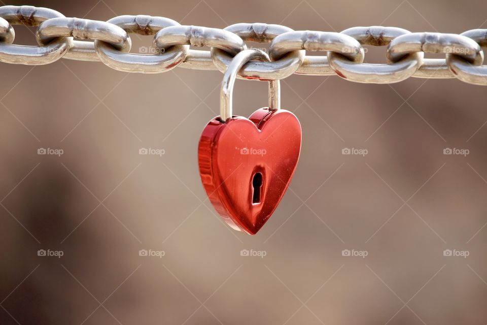Love, Red heart shaped padlock hanging on a steel chain - Kärlek , rött hänglås format som ett hjärta hänger på en kedja gjord i metall