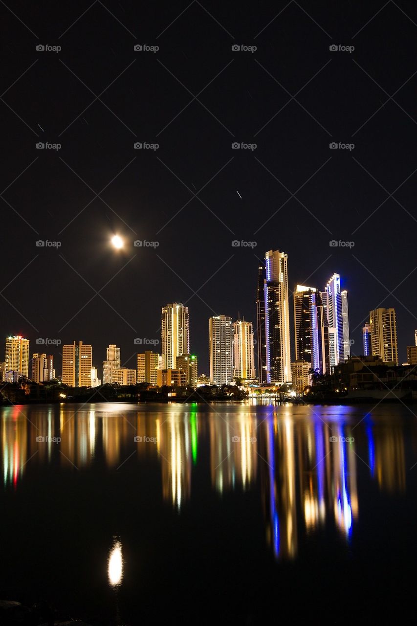 Illuminated building reflection on sea