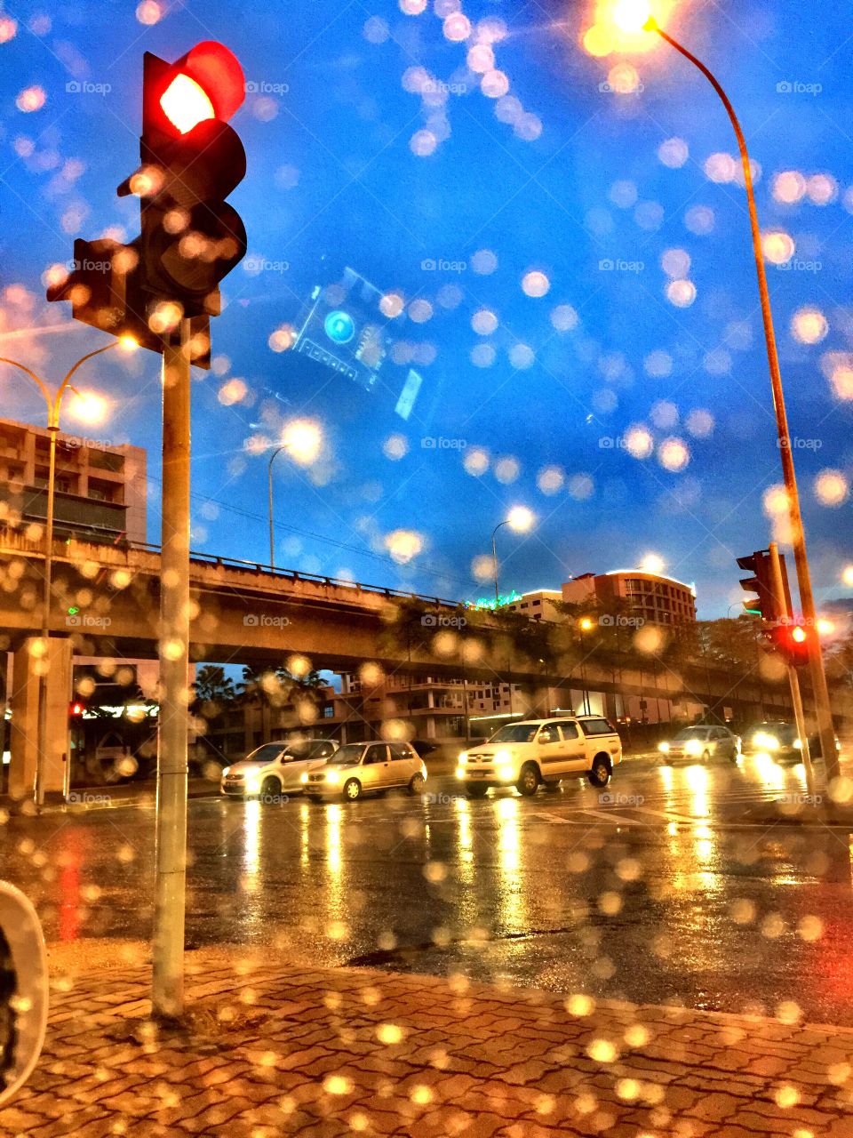 driving in the rain. waiting for the traffic light turn green