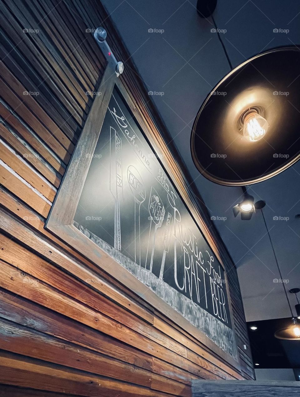 A chalkboard, a wooden wall, and some fun lighting, create a particularly rustic ambience. 