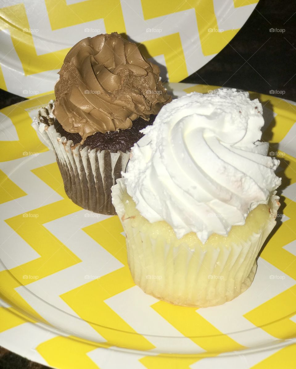 Delicious chocolate and vanilla cupcakes displayed on a yellow and white paper plate, serving cupcakes at a birthday party! USA, America 