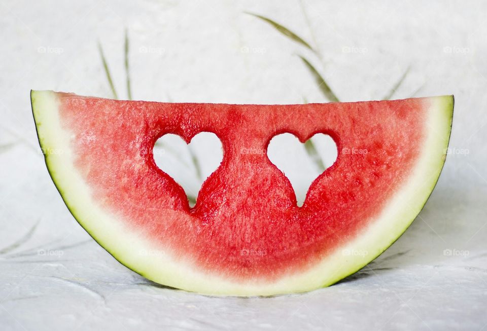 Hearts shape holes in watermelon slice