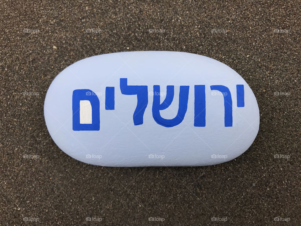 Jerusalem ירושלים, on a painted stone over black vulcanic sand 