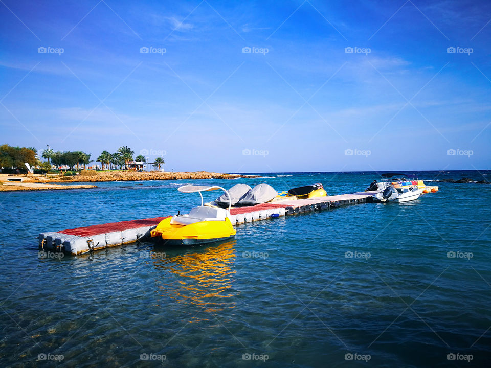 Sea view, blue sky and boats docked at the pontoon.