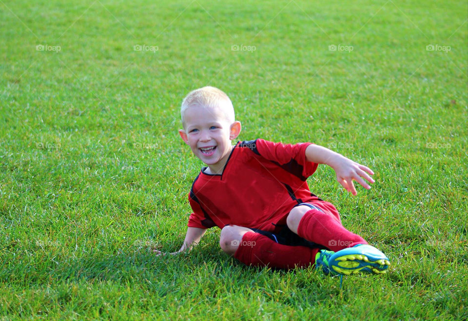 Boy Enjoying Soccer. Boy enjoys playing soccer on a sunny day