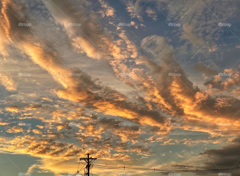 Clouds above a utility pole at sunset