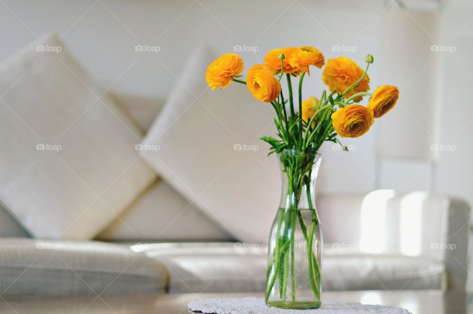 Bouquet of Yellow flowers,  ranunculus in a vase on a table in a cozy home on a sunny day.