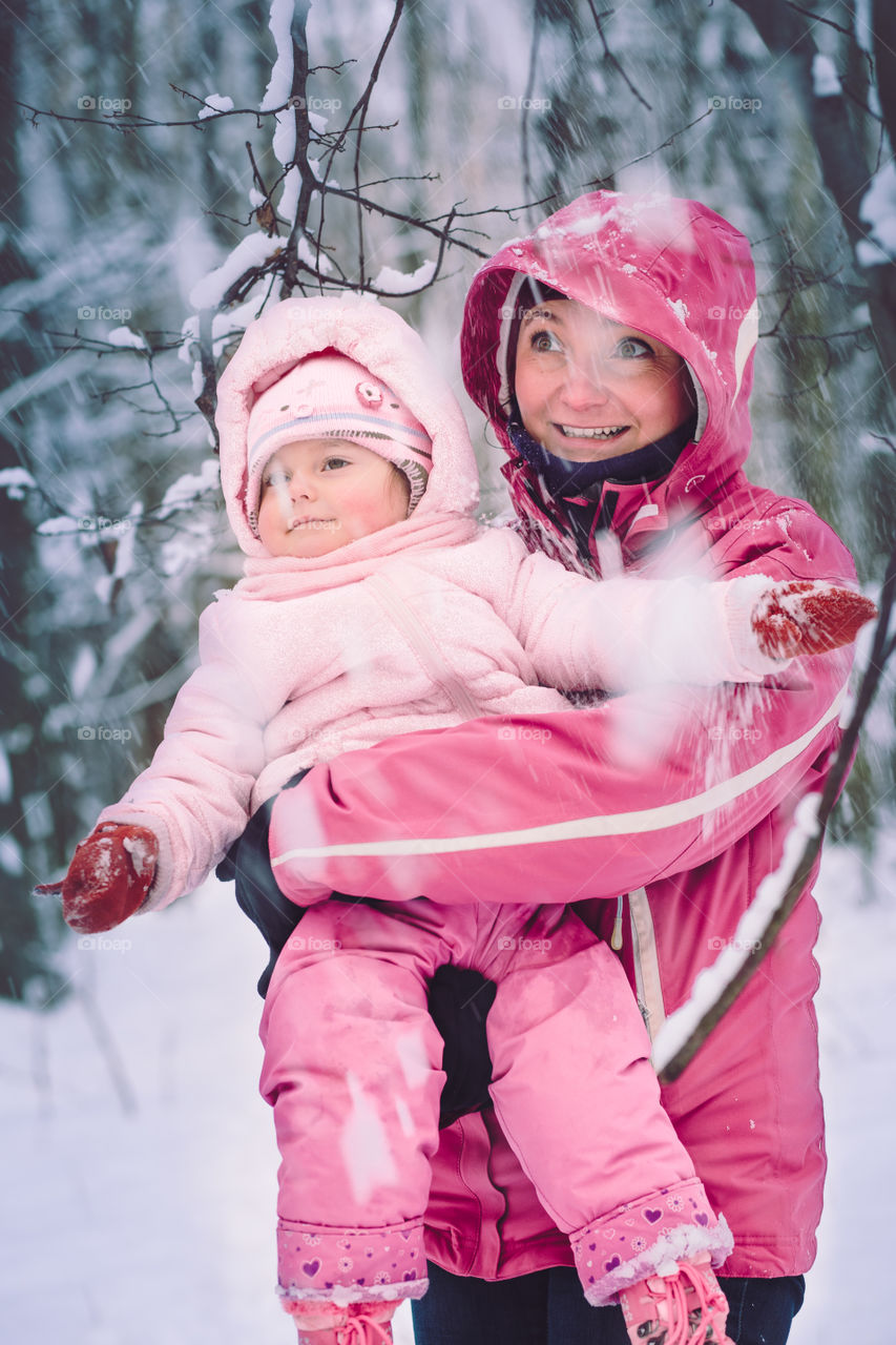 Mother spending time with her little daughter outdoors in the wintertime