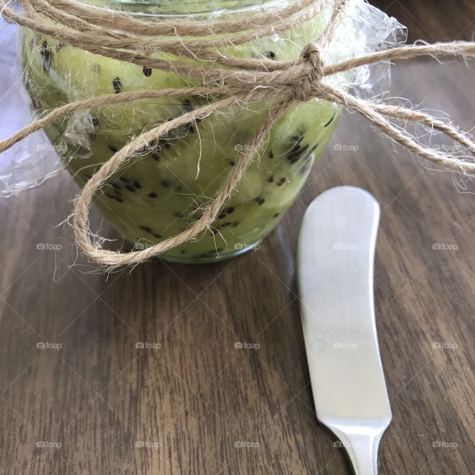 Homemade kiwi jam with crackers on wooden table 