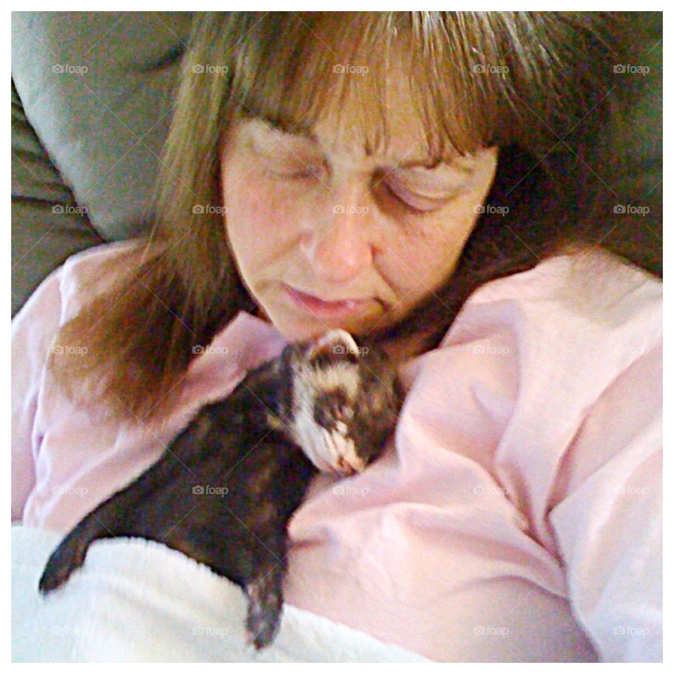 Cutest pets in the world. Ferret sleeping on woman (who is also sleeping). 