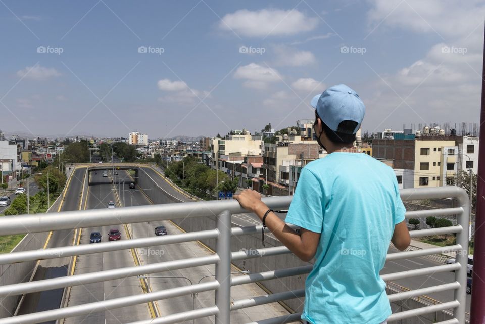 Young man looking out from a highway in the city