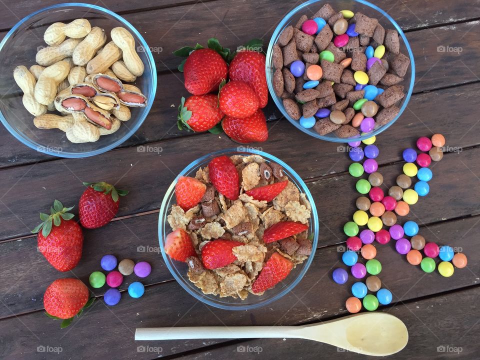 Different flakes with added strawberries, peanuts and colored chocolate candy