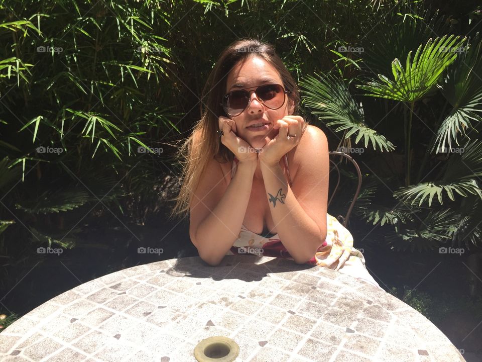 Woman in sunglasses sitting on chair at café