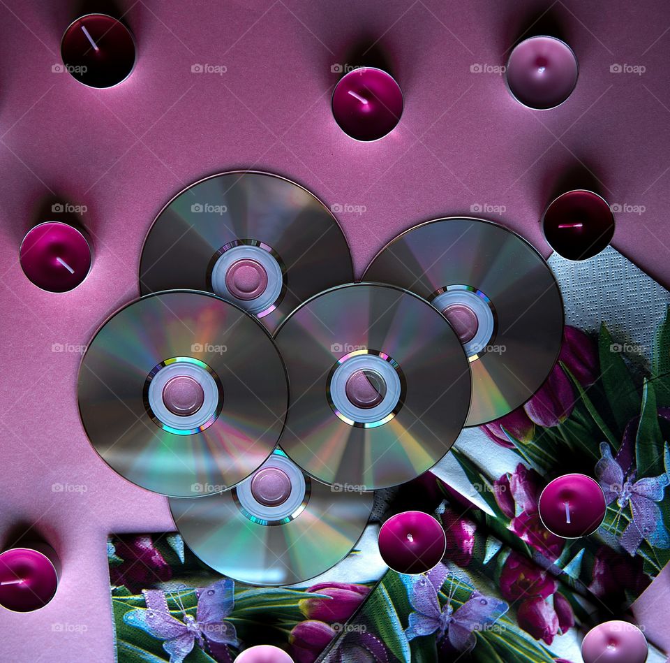 Top view of music discs and candles on purple