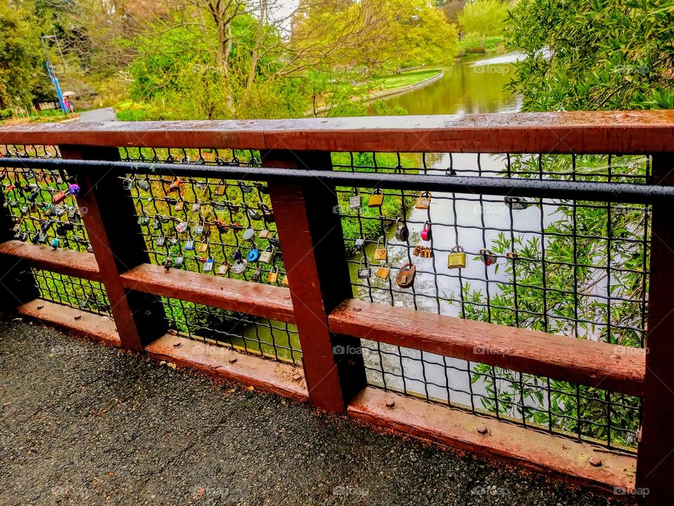 metal railing of bridge with love locks and wish locks