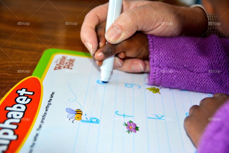 Grandfather helping child learn to write
