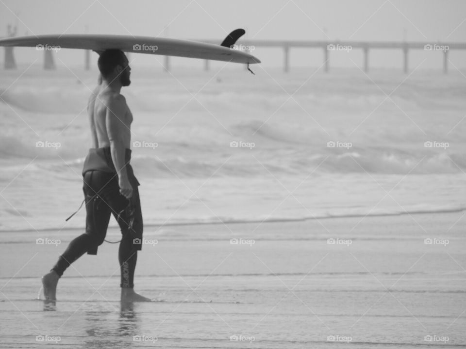 Calling it a day. Surfer coming in from the ocean.