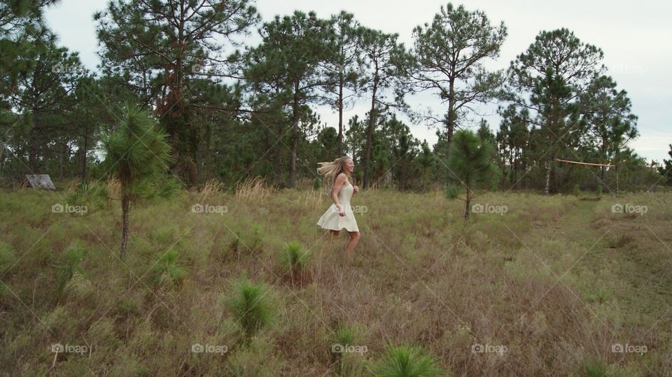Blonde girl dancing and spinning in nature