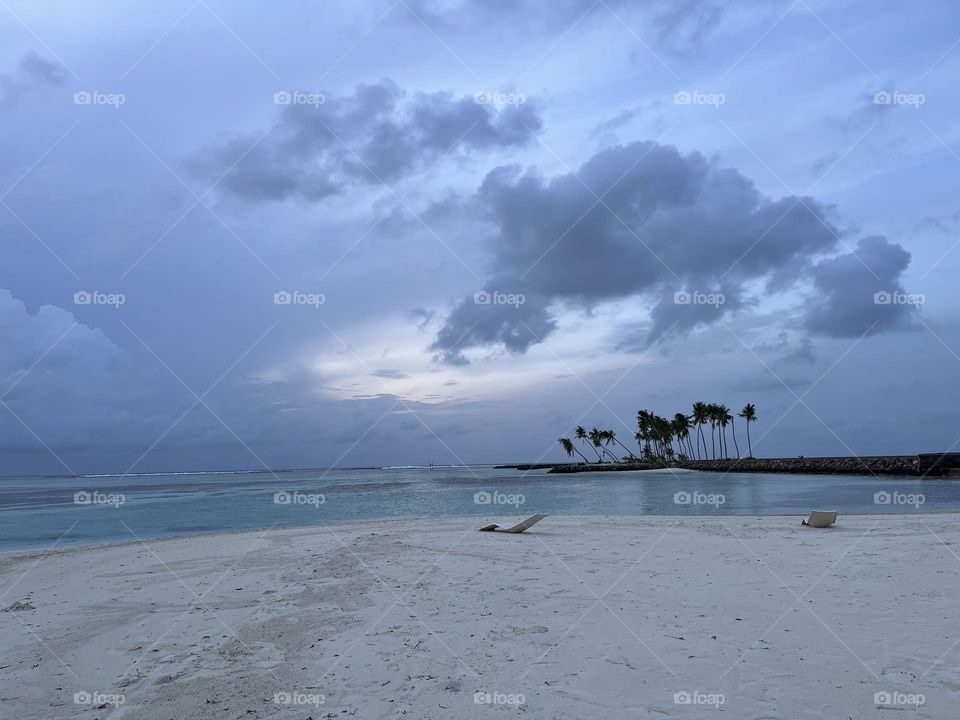 The far end of the Huraa island in the Kaafu atoll, Maldives. On a cloudy morning, grey clouds covered the horizon.