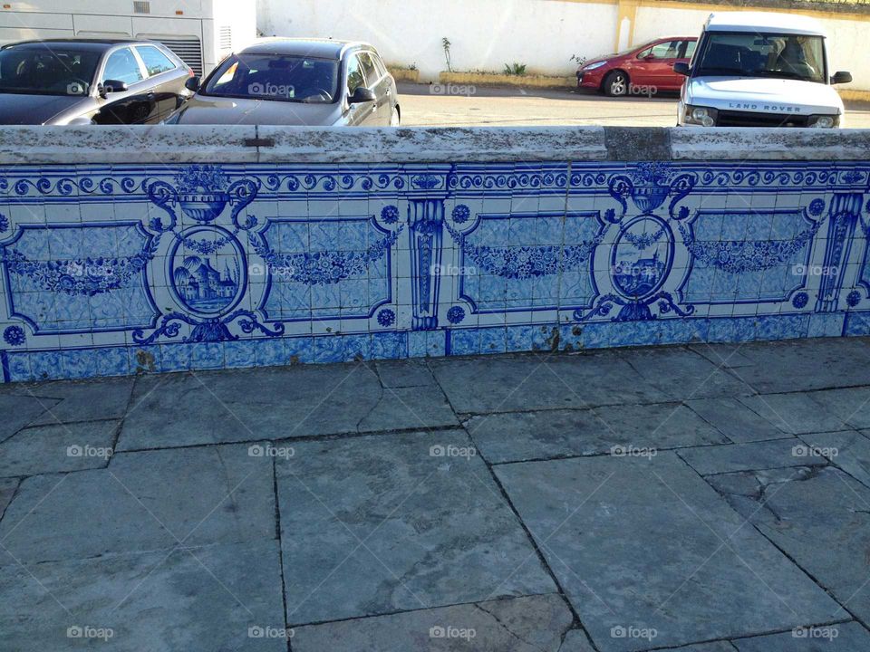 Muro com azulejos pintados perto de uma igreja