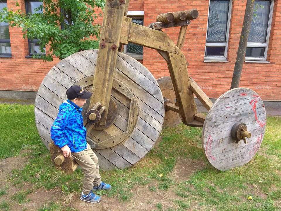 child and wooden bike street art