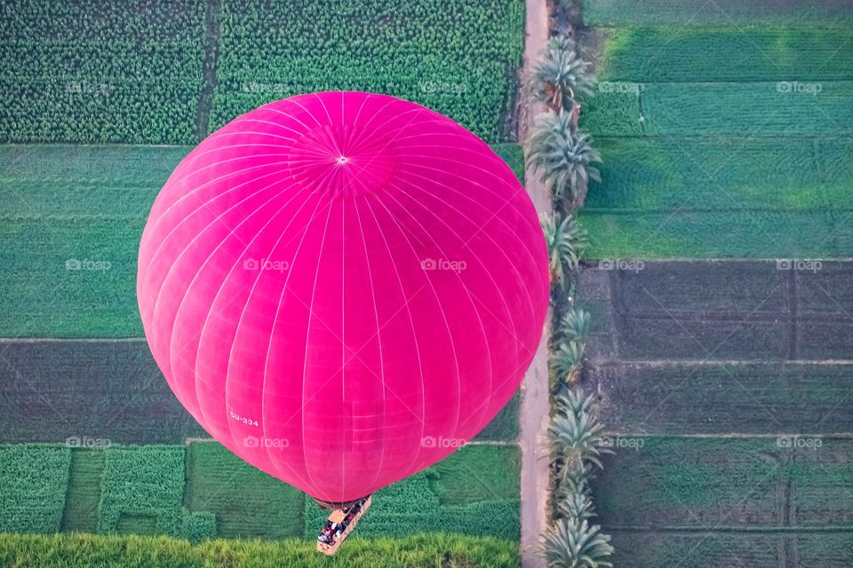 Top view of colorful balloon above green field