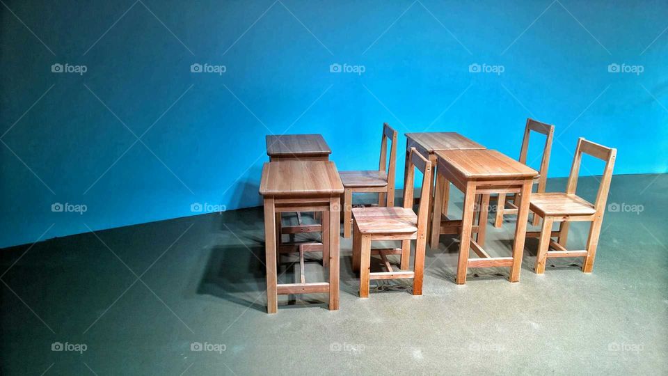 Alone seats in the room. Four tables and four chairs without students.