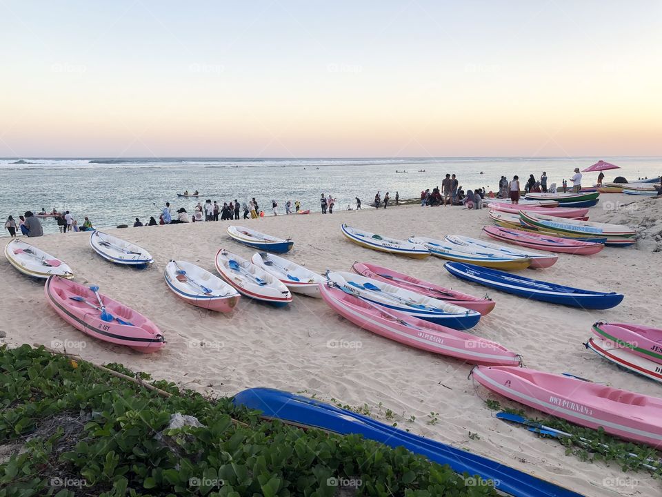 Pink and blue, beach canoes and kayaks at sunset. Landscape style. Taken August 2018.