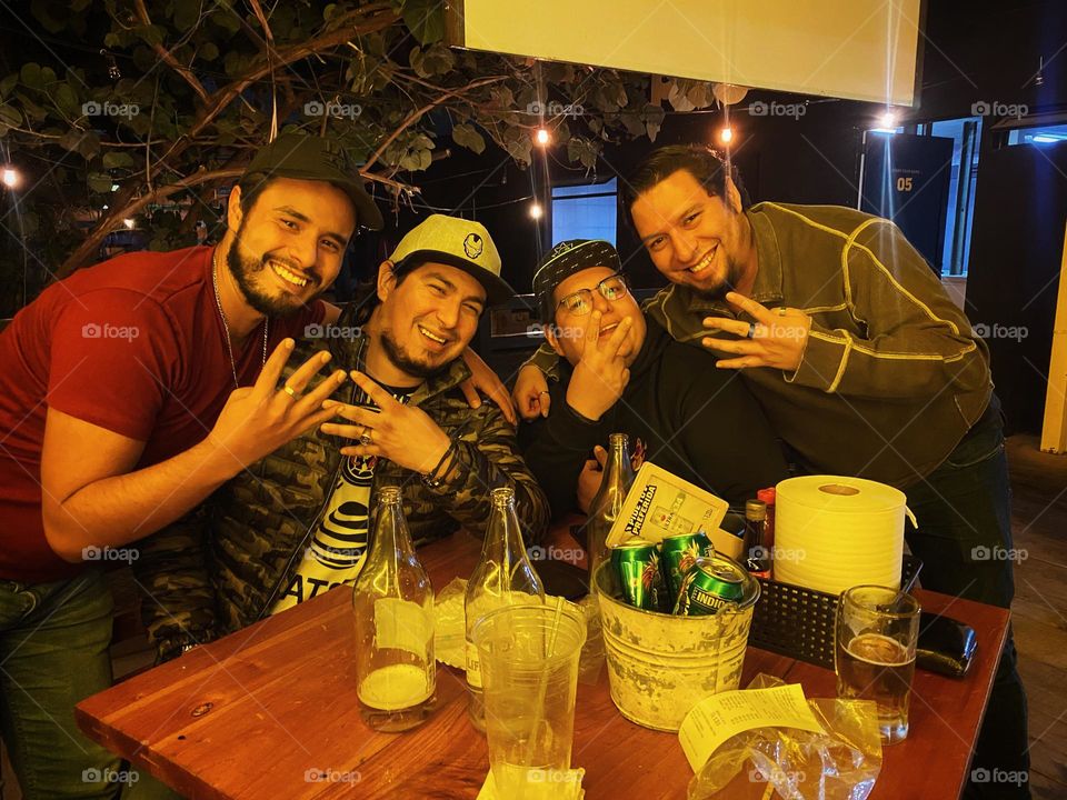 Group of man enjoying the night, drinking smiling and laughing, during the night.