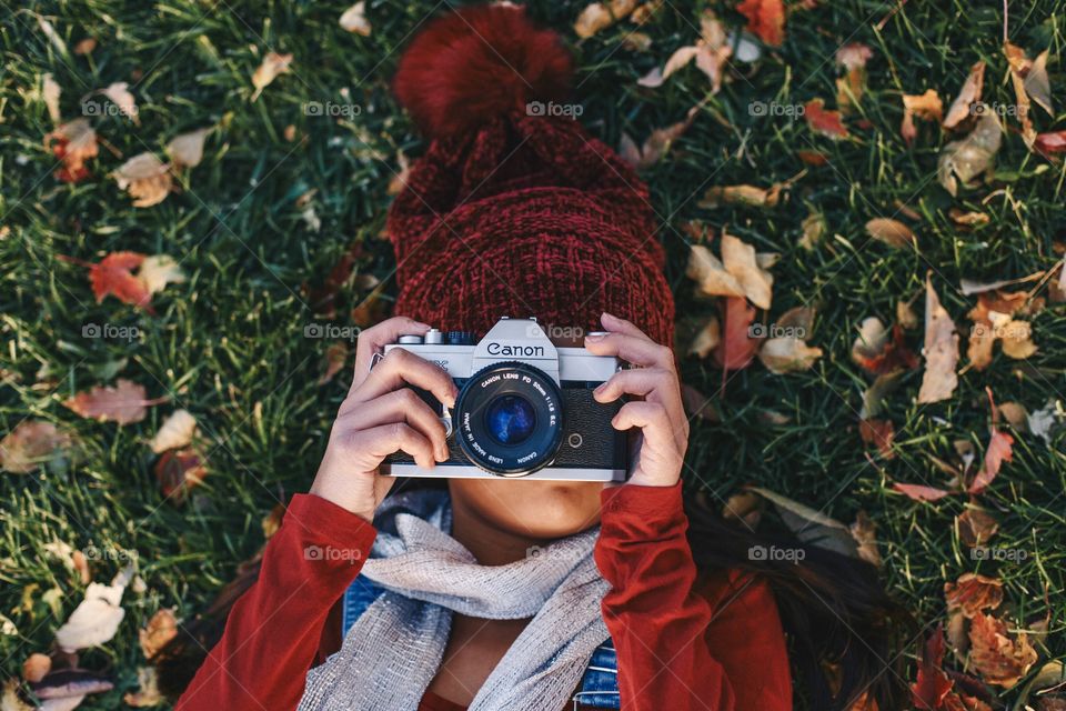 Girl taking photos on a film canon camera 