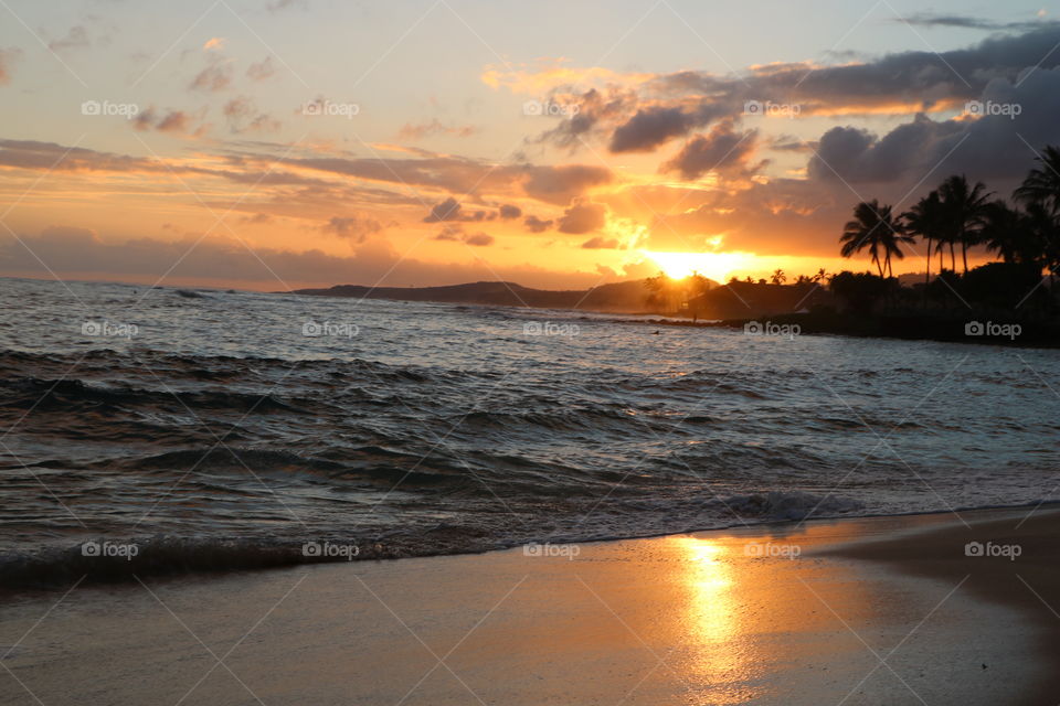 Sun is setting down casting golden light on the sky reflecting on the warm sand .. Tropical paradise spreading tranquility...