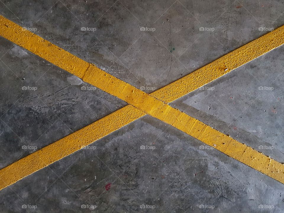 yellow cross marked on concrete floor