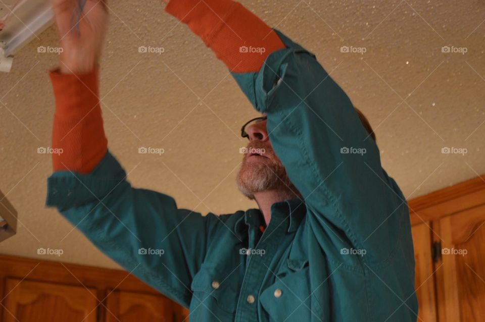 Man doing electrical above his head