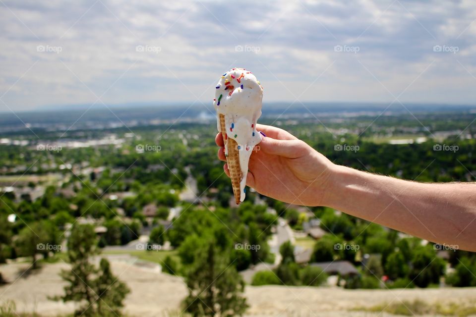 Hand holding melting ice cream cone