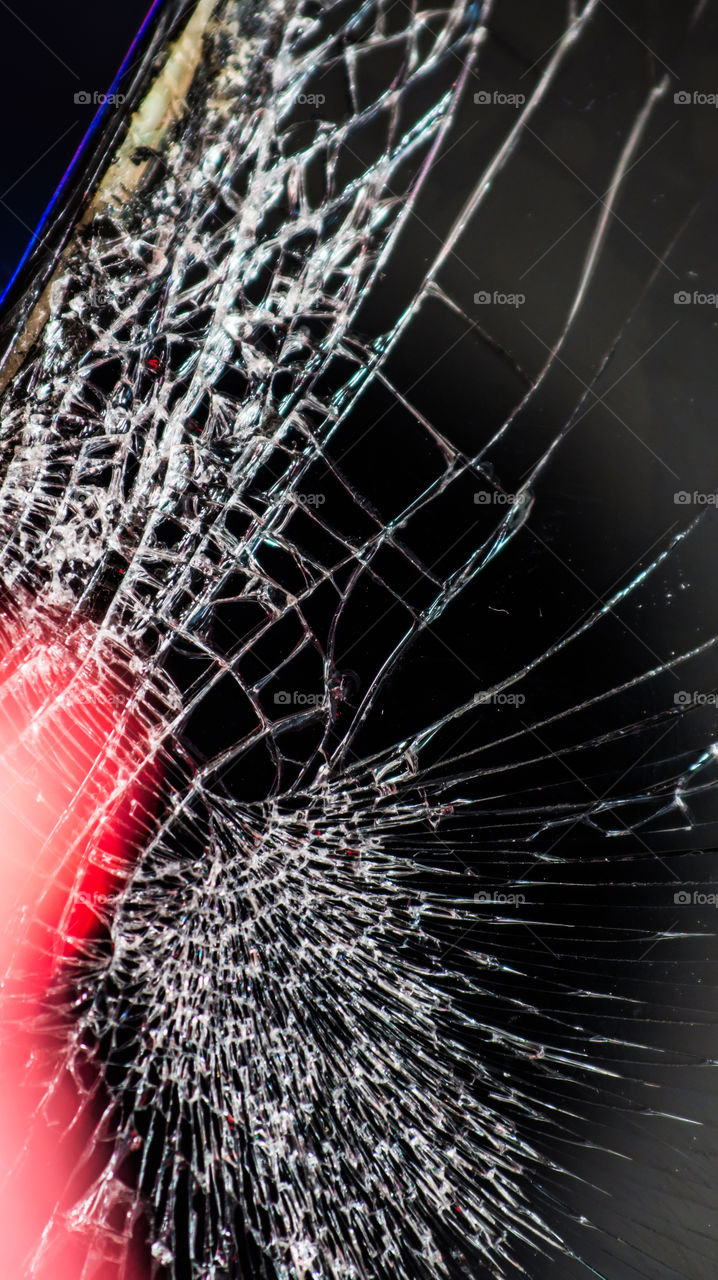 Multi-colored and bright broken smartphone screen close-up.