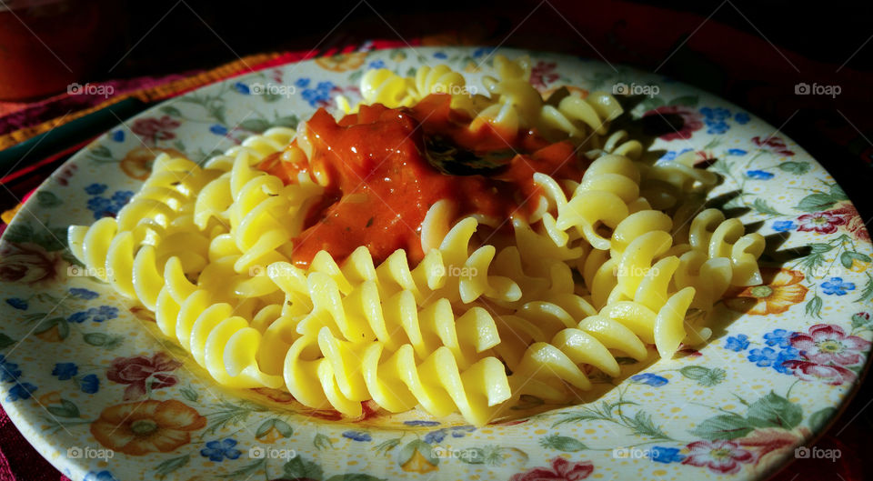 A plate of fusilli pasta and a red sauce